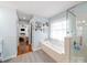 Bright bathroom featuring a glass shower, soaking tub, and updated tile flooring at 17118 Frog Pond Rd, Oakboro, NC 28129
