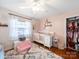 Well decorated Bedroom featuring hardwood floors, a ceiling fan, and a crib at 17118 Frog Pond Rd, Oakboro, NC 28129