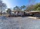 View of a house with gravel driveway and an awning covered parking area at 17118 Frog Pond Rd, Oakboro, NC 28129