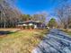 Charming single-story home features a well-maintained lawn, brick accents, and a long gravel driveway at 17118 Frog Pond Rd, Oakboro, NC 28129