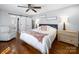 Bright main bedroom features a ceiling fan, hardwood floors, ensuite bath and a comfy sitting chair at 17118 Frog Pond Rd, Oakboro, NC 28129