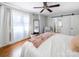 Bright main bedroom features a ceiling fan, hardwood floors, and sliding barn door to the main bathroom at 17118 Frog Pond Rd, Oakboro, NC 28129
