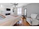 Relaxing main bedroom with a fireplace, hardwood floors, ceiling fan, and a comfortable chair at 17118 Frog Pond Rd, Oakboro, NC 28129
