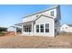 Rear exterior of a two-story home with a covered porch, and backyard with minimal landscaping at 338 Shinnville Rd, Mooresville, NC 28115