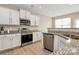 Well-lit kitchen featuring white cabinets, stainless steel appliances, and granite countertops at 4118 Caldwell Ridge Pkwy, Charlotte, NC 28213