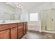 Bright main bathroom featuring dual sinks, a soaking tub, and a glass-enclosed shower at 4118 Caldwell Ridge Pkwy, Charlotte, NC 28213
