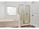 Relaxing main bathroom featuring a soaking tub, separate glass shower, and window for natural light at 4118 Caldwell Ridge Pkwy, Charlotte, NC 28213