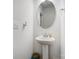 Bright half bathroom featuring pedestal sink, oval mirror, and convenient light switch at 5010 Arbordale Way # 5, Mount Holly, NC 28120