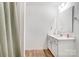Bright bathroom featuring a white vanity, modern mirror, wood-look flooring, and a textured shower curtain at 5010 Arbordale Way # 5, Mount Holly, NC 28120