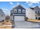 Charming two-story home showcasing a well-manicured lawn and a driveway leading to a two-car garage at 5010 Arbordale Way # 5, Mount Holly, NC 28120