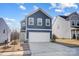 Charming two-story home showcasing a well-manicured lawn and a driveway leading to a two-car garage at 5010 Arbordale Way # 5, Mount Holly, NC 28120
