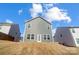 Rear elevation of home with gray siding, double-hung windows, glass-paned back door, and a gentle slope at 5010 Arbordale Way # 5, Mount Holly, NC 28120