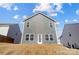 Rear exterior of home with gray siding, double-hung windows and a glass-paned back door at 5010 Arbordale Way # 5, Mount Holly, NC 28120