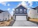 Charming two-story home showcasing a well-manicured lawn and a driveway leading to a two-car garage at 5010 Arbordale Way # 5, Mount Holly, NC 28120