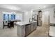 Open kitchen featuring an island, modern appliances, gray cabinets and views of the connected living and dining area at 5010 Arbordale Way # 5, Mount Holly, NC 28120