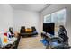 Cozy living area with wood floors, a black futon, and large windows for ample light at 5010 Arbordale Way # 5, Mount Holly, NC 28120