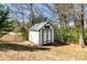 View of a backyard shed featuring light gray paint with a gray roof and double doors surrounded by a black metal fence at 5020 Clover Hill Rd # 61, Indian Trail, NC 28079