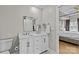A bright bathroom with a double sink vanity, a large mirror, and a view into a stylish bedroom at 721 Governor Morrison St # 408, Charlotte, NC 28211