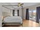 Bright bedroom with a four-poster bed, hardwood floors, modern ceiling fan, and a balcony overlooking city buildings at 721 Governor Morrison St # 408, Charlotte, NC 28211