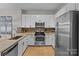 Well-equipped kitchen with stainless steel appliances, granite countertops, and modern white cabinets at 721 Governor Morrison St # 408, Charlotte, NC 28211