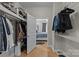 Bright walk-in closet featuring custom shelving and hanging space, with an open door to a bedroom with neutral decor at 721 Governor Morrison St # 408, Charlotte, NC 28211