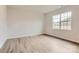 A bright, empty bedroom with wood-look flooring and a large window offering lots of natural light at 8418 Norman Forest Rd, Lancaster, SC 29720