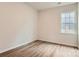 An empty bedroom featuring wood-look flooring, neutral walls, and a bright window at 8418 Norman Forest Rd, Lancaster, SC 29720