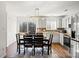 Bright eat-in kitchen with stainless steel appliances, white cabinets, and a tiled backsplash at 10337 Hugue Way, Charlotte, NC 28214