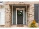 Close-up of the front door with a decorative wreath, framed by brick and a stylish welcome mat at 1037 Naples Dr, Davidson, NC 28036