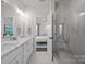 Bright main bathroom featuring double sinks, marble countertops and a glass-enclosed shower at 1037 Naples Dr, Davidson, NC 28036