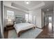 Main bedroom with hardwood floors, tray ceiling, and a doorway to the main bathroom at 1037 Naples Dr, Davidson, NC 28036