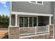 Covered patio featuring a grill, white railing, brick facade, and string lights at 1037 Naples Dr, Davidson, NC 28036