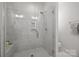 Bright, glass-enclosed shower features white marble tile and built in shower caddy at 1037 Naples Dr, Davidson, NC 28036