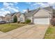 Charming home featuring an attached two-car garage, tidy landscaping, and light siding at 10722 Mountain Springs Dr, Charlotte, NC 28278