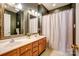 Well-lit bathroom featuring a double vanity, decorative mirrors, and a shower-tub combination at 11010 Pale Hickory Ln, Charlotte, NC 28215