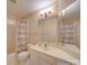 A clean bathroom with a single vanity, neutral tile, and a shower with a patterned curtain at 1162 W 1St St, Charlotte, NC 28202