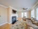 Cozy living room with a fireplace, hardwood floors, a ceiling fan, and large windows at 1162 W 1St St, Charlotte, NC 28202