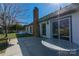 Backyard patio features a fireplace, seating, and mature trees offering shade at 12012 Stainsby Ln, Charlotte, NC 28273