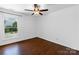 Bedroom featuring hardwood floors, a ceiling fan, and a bright window at 12012 Stainsby Ln, Charlotte, NC 28273