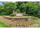 Beautifully landscaped community entrance with stone signage and colorful flowerbeds at 12012 Stainsby Ln, Charlotte, NC 28273