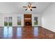 Inviting living room featuring a brick fireplace, ceiling fan, and bright natural light at 12012 Stainsby Ln, Charlotte, NC 28273