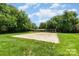Sand volleyball court surrounded by green grass and mature trees, perfect for outdoor fun at 12012 Stainsby Ln, Charlotte, NC 28273
