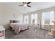 Bright bedroom featuring a ceiling fan, plush carpet, and plenty of natural light from the windows at 1205 Skywatch Ln, Monroe, NC 28112