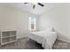 Cozy bedroom features neutral walls, ceiling fan, and a sunny window with a white curtain at 1205 Skywatch Ln, Monroe, NC 28112