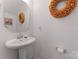 Elegant powder room with a pedestal sink, decorative mirror, and modern fixtures at 1205 Skywatch Ln, Monroe, NC 28112