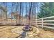 Backyard fire pit with stone surround, bordered by a white fence, creating a cozy outdoor gathering spot at 125 Rocky Trail Ct, Fort Mill, SC 29715