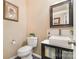 Cozy half-bathroom with pedestal sink, framed mirror, toilet, and artwork at 148 Painted Bunting Dr, Troutman, NC 28166