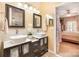 Dual vanity bathroom with modern sinks, updated fixtures, and a doorway leading to a bedroom at 148 Painted Bunting Dr, Troutman, NC 28166