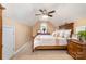 A cozy bedroom featuring carpeted floors, a ceiling fan, and ample natural light at 148 Painted Bunting Dr, Troutman, NC 28166