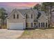 Charming two-story home featuring neutral siding, black shutters, and an attached two-car garage at 148 Painted Bunting Dr, Troutman, NC 28166